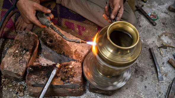 Finishing a brass urn with a blowtorch