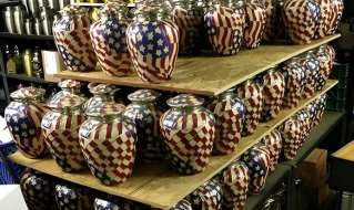 Tiered display of American flag themed brass cremation urns