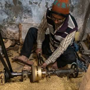 Craftsman spinning a brass component on a manual lathe